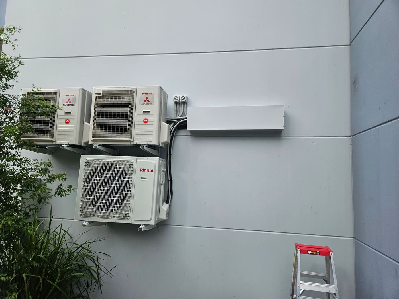 Completed AKO Air multi-unit outdoor air conditioning installation on a commercial wall